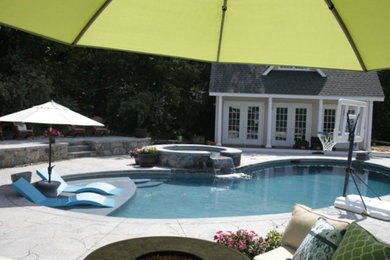 Hot tub - large transitional backyard stone and kidney-shaped hot tub idea in New York