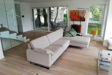 Großes, Offenes Modernes Wohnzimmer mit gebeiztem Holzboden in München