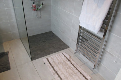 Photo of a large contemporary kids bathroom in Other with flat-panel cabinets, medium wood cabinets, an open shower, a two-piece toilet, gray tile, ceramic tile, grey walls, ceramic floors and a drop-in sink.