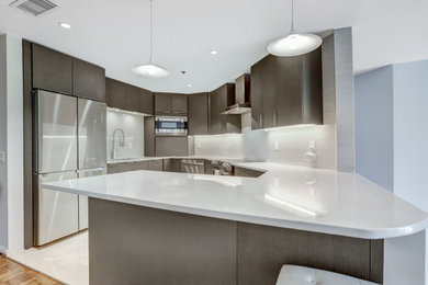 Example of a mid-sized trendy u-shaped eat-in kitchen design in DC Metro with a drop-in sink, flat-panel cabinets, brown cabinets, quartz countertops, stainless steel appliances, a peninsula and white countertops