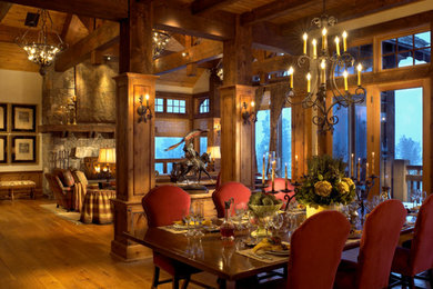 Inspiration for a rustic medium tone wood floor great room remodel in Denver with a stone fireplace