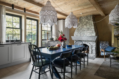 This is an example of a mid-sized country open plan dining in Moscow with beige walls, porcelain floors, a standard fireplace, a stone fireplace surround and beige floor.