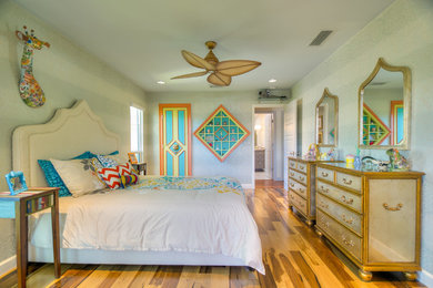 Mid-sized island style master medium tone wood floor bedroom photo in Tampa with white walls and no fireplace