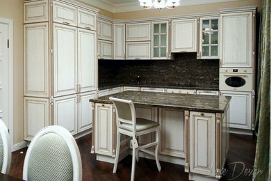 Стильный дизайн: угловая кухня в классическом стиле с обеденным столом, монолитной мойкой, белыми фасадами, столешницей из акрилового камня и островом - последний тренд