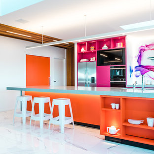 Cette image montre une grande arrière-cuisine parallèle design avec un évier encastré, des portes de placard oranges, un plan de travail en quartz, une crédence multicolore, une crédence en feuille de verre, un électroménager en acier inoxydable, un sol en carrelage de céramique, un îlot central, un sol blanc et un plan de travail gris.