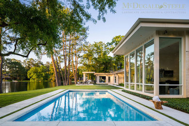 This is an example of a mid-sized contemporary backyard rectangular pool in Houston with concrete slab.