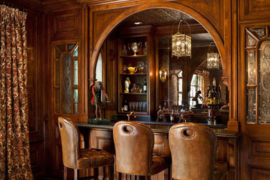 Traditional home bar in San Francisco with raised-panel cabinets, dark wood cabinets, brown splashback, dark hardwood floors and brown floor.
