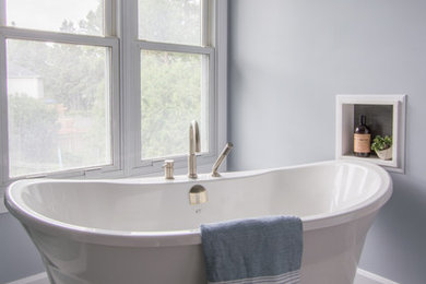Large transitional master black tile and ceramic tile ceramic tile and black floor bathroom photo in Other with raised-panel cabinets, white cabinets, a two-piece toilet, blue walls, an undermount sink, quartzite countertops, a hinged shower door and white countertops