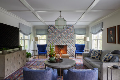 Example of a transitional open concept medium tone wood floor, brown floor and coffered ceiling living room design in Chicago with a standard fireplace, a tile fireplace, a wall-mounted tv and blue walls