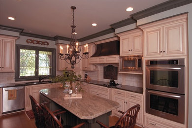 Example of a kitchen design in Other with light wood cabinets, stainless steel appliances and an island