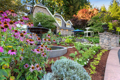 Inspiration for a large traditional drought-tolerant and full sun front yard concrete paver and metal fence landscaping in Portland.
