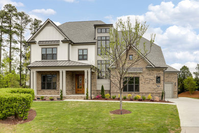 Large transitional beige three-story mixed siding and board and batten house exterior photo in Raleigh with a clipped gable roof, a mixed material roof and a gray roof