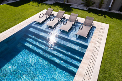Pool - backyard tile and rectangular pool idea in Other