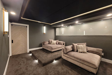 Large trendy carpeted and gray floor home theater photo in Austin with gray walls and a wall-mounted tv