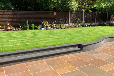 Photo of a medium sized classic back patio in Hertfordshire with natural stone paving.