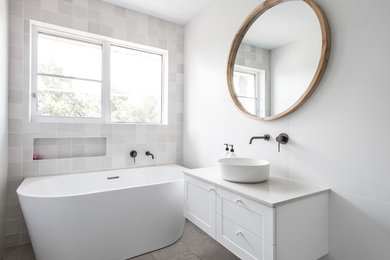 Inspiration for a small beach style master bathroom in Melbourne with white cabinets, a corner tub, a corner shower, white tile, ceramic tile, white walls, ceramic floors, a vessel sink, laminate benchtops, beige floor, a hinged shower door and white benchtops.