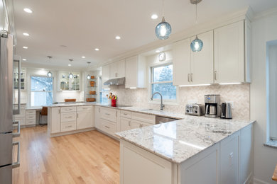 This is an example of a medium sized classic u-shaped kitchen/diner in Indianapolis with flat-panel cabinets, white cabinets, engineered stone countertops, white splashback, cement tile splashback, stainless steel appliances, a breakfast bar and white worktops.