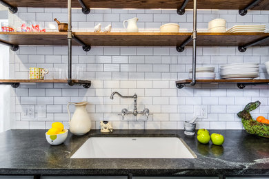 Small industrial galley separate kitchen in Boston with an undermount sink, shaker cabinets, grey cabinets, white splashback, subway tile splashback, no island, soapstone benchtops, stainless steel appliances, slate floors and brown floor.