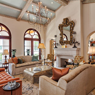 Foto de salón abierto, mediterráneo, con paredes beige, chimenea de doble cara y marco de chimenea de piedra