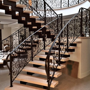 This is an example of a large traditional tiled u-shaped metal railing staircase in Vancouver with open risers.