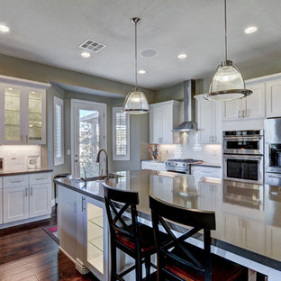 Mid-sized modern kitchen pantry ideas - Example of a mid-sized minimalist u-shaped ceramic floor kitchen pantry design in Las Vegas with a farmhouse sink, shaker cabinets, white cabinets, quartzite countertops, white backsplash, subway tile backsplash, stainless steel appliances and an island