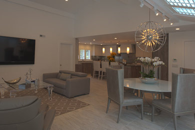 Modelo de salón abierto contemporáneo de tamaño medio con paredes blancas, suelo de baldosas de porcelana y televisor colgado en la pared
