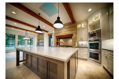 Design ideas for a transitional l-shaped eat-in kitchen in Dallas with a farmhouse sink, shaker cabinets, white cabinets, quartz benchtops, metallic splashback, metal splashback, stainless steel appliances, porcelain floors, with island and grey floor.