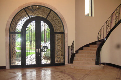 Entryway - huge travertine floor entryway idea in Houston with beige walls and a glass front door