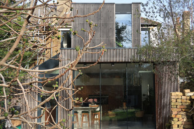 Inspiration for a gey contemporary two floor rear extension in London with wood cladding.