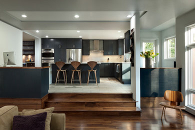 Inspiration for a contemporary l-shaped eat-in kitchen remodel in DC Metro with flat-panel cabinets, black cabinets, stainless steel appliances and an island