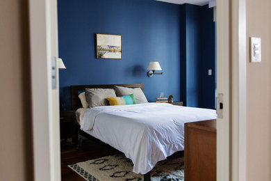 Design ideas for a mid-sized midcentury master bedroom in New York with blue walls, dark hardwood floors and no fireplace.