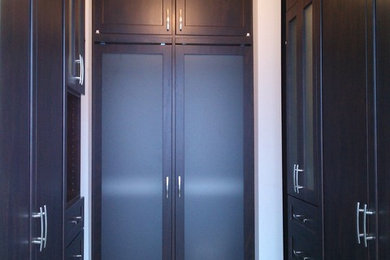Foto de armario vestidor unisex contemporáneo de tamaño medio con armarios estilo shaker, puertas de armario de madera en tonos medios y suelo de madera oscura