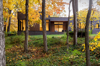 Idee per la villa multicolore moderna a un piano con rivestimento in mattoni, tetto piano e tetto nero