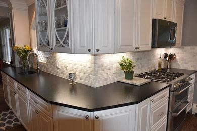 Inspiration for a large traditional l-shaped separate kitchen in Chicago with an undermount sink, raised-panel cabinets, white cabinets, granite benchtops, grey splashback, subway tile splashback, white appliances, dark hardwood floors, with island and brown floor.