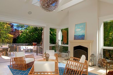 Large transitional sunroom in Chicago with travertine floors, a standard fireplace, a stone fireplace surround, a skylight and beige floor.