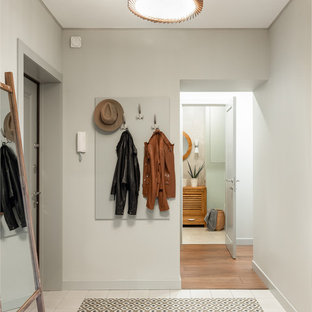 Ispirazione per un corridoio design di medie dimensioni con pareti grigie, pavimento in gres porcellanato, una porta singola, una porta grigia e pavimento multicolore