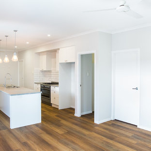 タウンズビルの中サイズのコンテンポラリースタイルのLDKの画像 (グレーの壁、クッションフロア、暖炉なし、茶色い床)