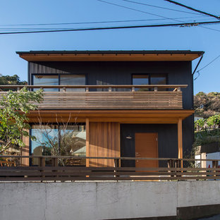 他の地域のアジアンスタイルのおしゃれな家の外観 (黒い外壁、切妻屋根) の写真