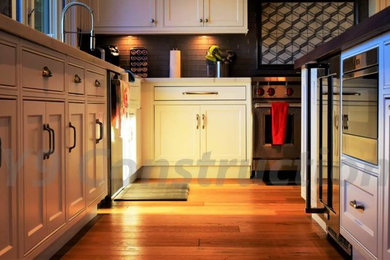 Example of a mid-sized transitional u-shaped light wood floor eat-in kitchen design in San Diego with a double-bowl sink, raised-panel cabinets, white cabinets, granite countertops, gray backsplash, ceramic backsplash, stainless steel appliances and an island