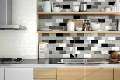 Enclosed kitchen - mid-sized contemporary galley enclosed kitchen idea in Austin with a drop-in sink, flat-panel cabinets, light wood cabinets, multicolored backsplash, ceramic backsplash, stainless steel appliances and no island