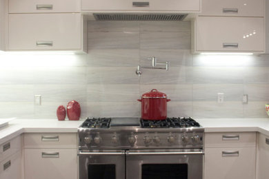 Eat-in kitchen - mid-sized modern u-shaped dark wood floor eat-in kitchen idea in Toronto with an undermount sink, flat-panel cabinets, beige cabinets, quartz countertops, stainless steel appliances and a peninsula