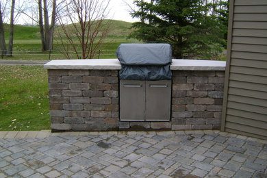Photo of a small traditional partial sun backyard concrete paver landscaping in Other.