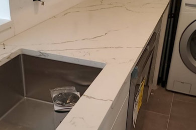 Inspiration for a mid-sized modern galley enclosed kitchen remodel in New York with an undermount sink, flat-panel cabinets, quartz countertops and white countertops