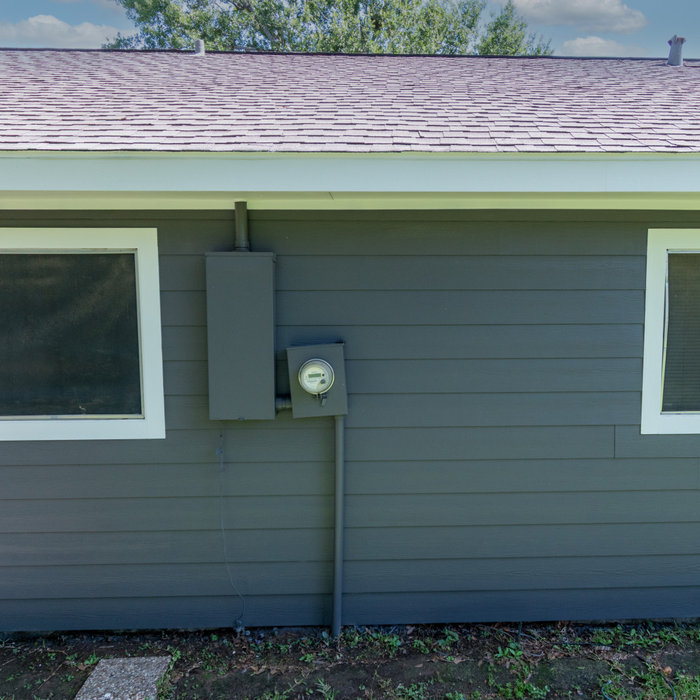 Back of house with new Hardie siding with cables and wires removed.