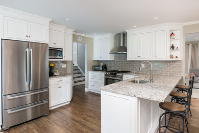 Photo of a large country eat-in kitchen in New York with an undermount sink, beaded inset cabinets, white cabinets, quartzite benchtops, grey splashback, glass tile splashback, stainless steel appliances, dark hardwood floors, with island, brown floor and multi-coloured benchtop.