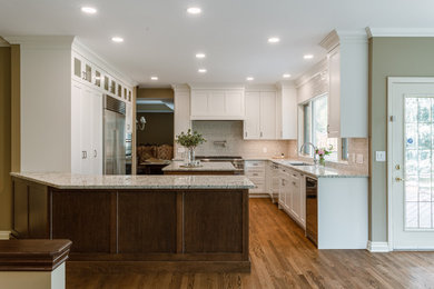 Inspiration for a mid-sized timeless dark wood floor and brown floor kitchen remodel in Calgary with an undermount sink, recessed-panel cabinets, white cabinets, quartzite countertops, white backsplash, ceramic backsplash, stainless steel appliances, an island and multicolored countertops