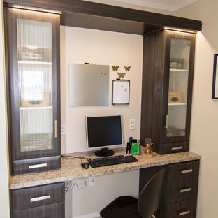 Photo of a small modern home office and library in Calgary with white walls, lino flooring and a built-in desk.