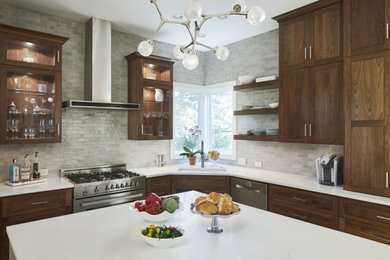 Large transitional l-shaped porcelain tile and gray floor kitchen photo in Austin with an undermount sink, shaker cabinets, dark wood cabinets, quartz countertops, green backsplash, glass tile backsplash, stainless steel appliances, an island and white countertops