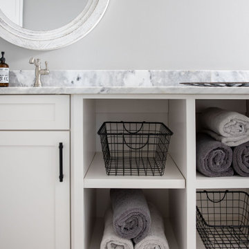 Built-In Linen Storage with Wire Baskets and Round Mirror