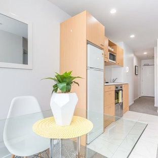 Новый формат декора квартиры: маленькая кухня в стиле модернизм с обеденным столом, ковровым покрытием и серым полом